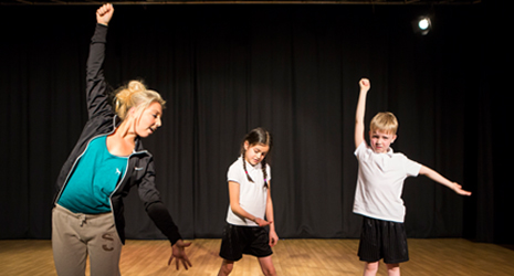 two child performers and an adult doing poses