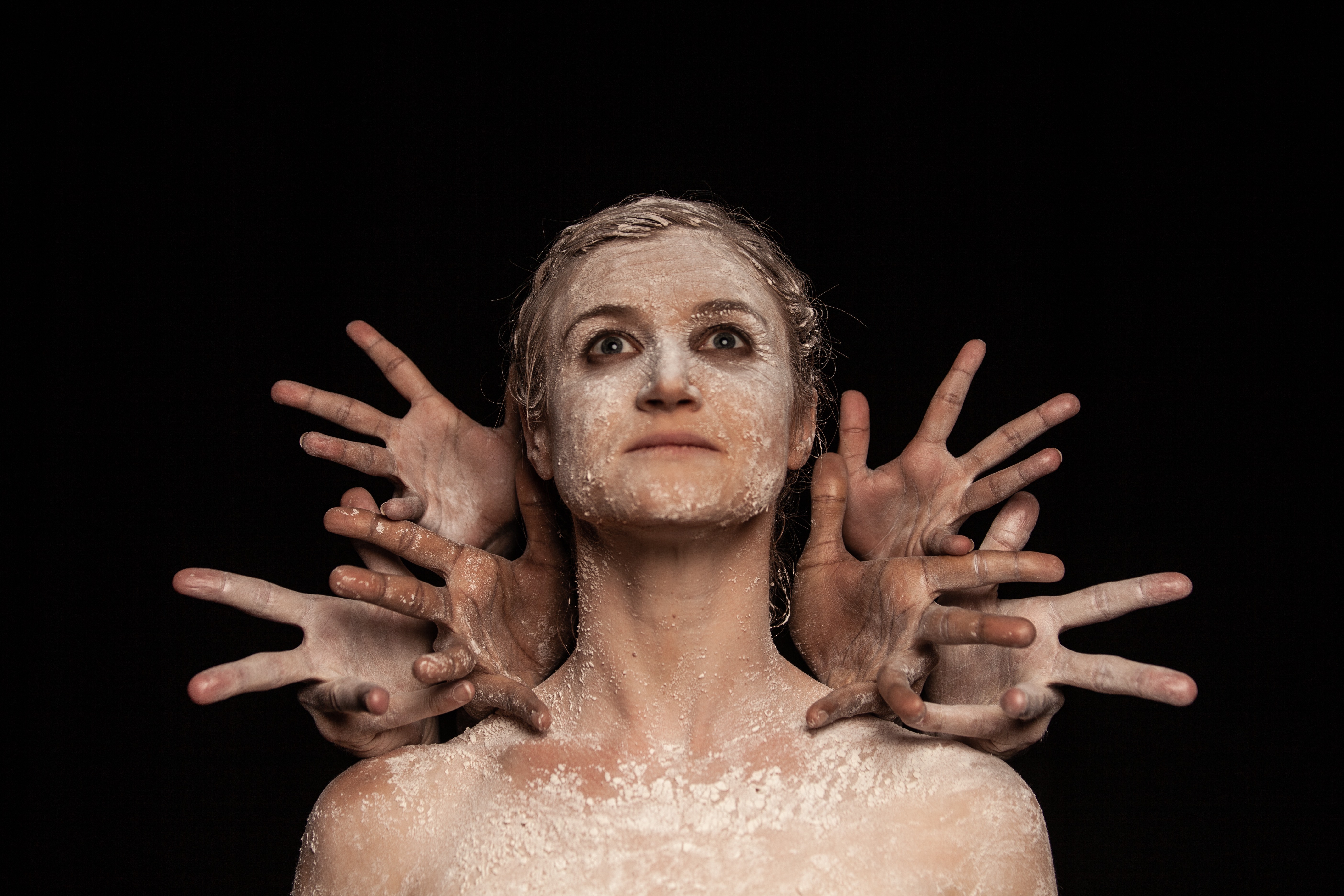 lady looking ahead with five hands reaching out near hear head