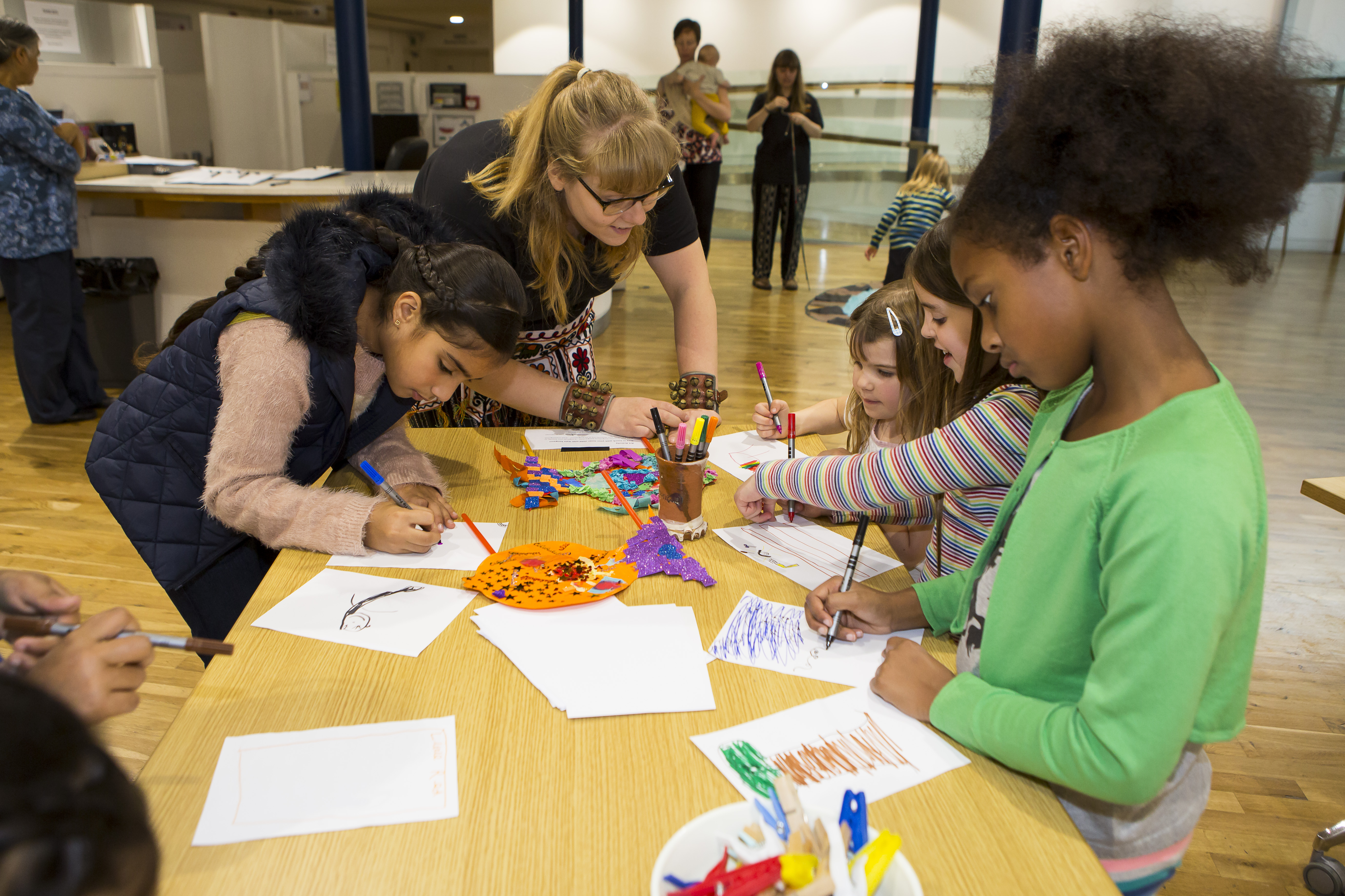 group of children drawing on a wooden table