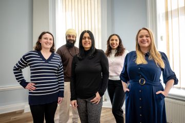 A group shot of 5 people smiling