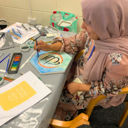 A woman doing some arabic calligraphy