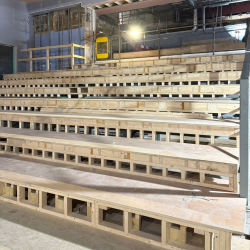 A photo of wooden beams that will be turned into theatre seating