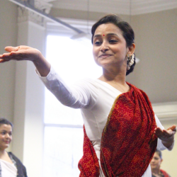 A female kathak dancer in a red and white dress