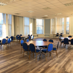A room of tables, chairs and floor length windows